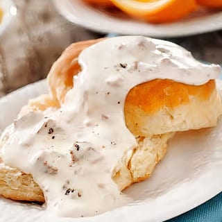 Fluffy biscuits topped with creamy, peppered gravy.