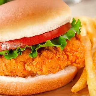 Fried chicken breast sandwich. Served with lettuce, tomatoes, pickles, onions and fries.