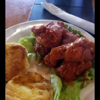 Five seasoned chicken wings paired with slices of grilled bread