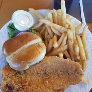 Catfish sandwich. Served with lettuce, tomatoes, pickles, onions and fries.