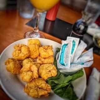 Golden-battered shrimp, served with a side of fresh greens.
